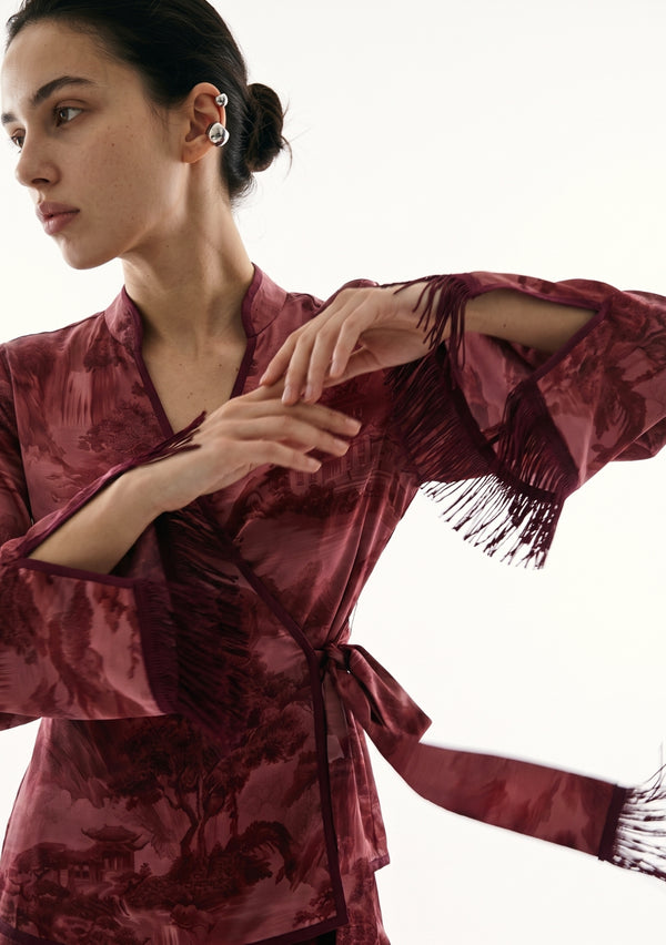 Crimson Dusk Set upper body detail, model with arms crossed as the silk fringe on the sleeve cuffs and the belt swings in motion