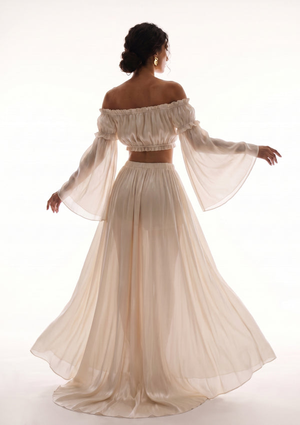 Sirocco cream satin-chiffon maxi skirt back view worn on-model with the sheer bell-sleeve crop top, dynamic twirl pose