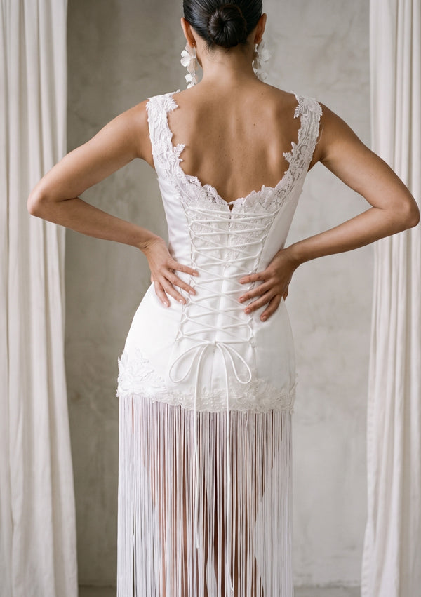 Lily Dress back view: open upper back, crossed lace-up and fringe falling to the floor
