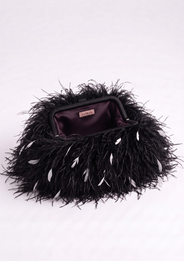 Black Feather Bag open: black frame and dark plum lining with the La Musa label inside.