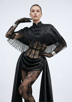 La Musa Baccara cropped black satin-jacquard fringe capelet with a mandarin collar and frog closures, layered over the Baccara corset, front view