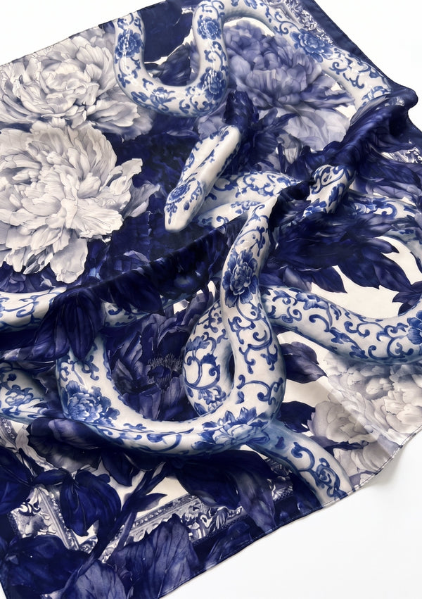Mirage Peony Scarf draped at an angle, revealing the hidden serpent head among blue and white peonies and the baroque border
