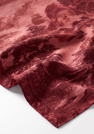 Corner detail of the Crimson Dusk silk scarf showing the finely rolled edge and the ornamental border framing the pagoda landscape print