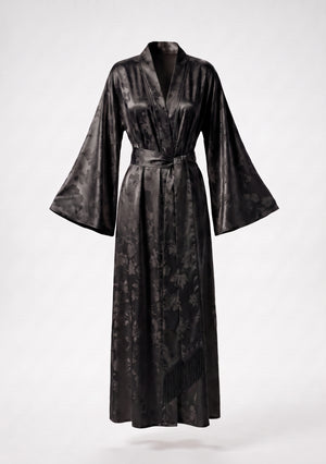Tenebrae robe shown on an invisible mannequin, wide sleeves spread to show the tonal woven floral, with the fringed sash falling across the front