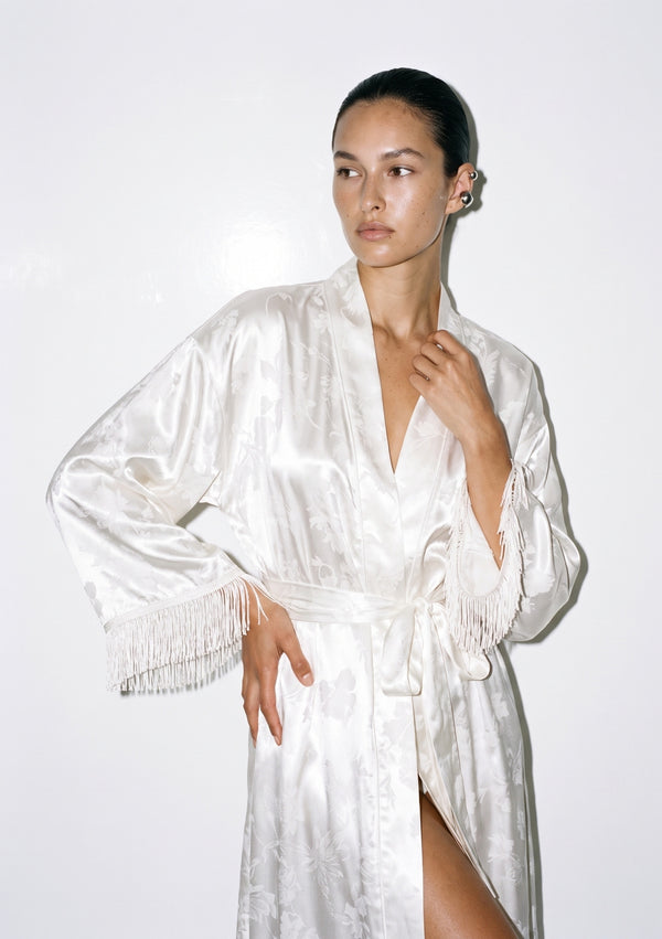 Close view of the Moonveil robe, deep V collar and the silk fringe running along the wide sleeve cuff