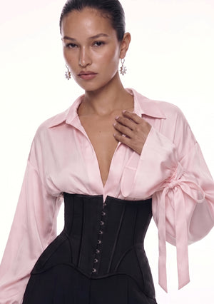 Close-up of the corset bodice with centre-front busk closure over a blush satin blouse.