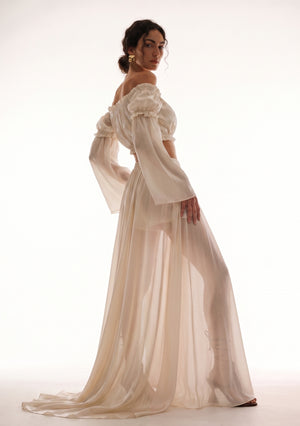 Sirocco cream satin-chiffon maxi skirt side view worn on-model showing the sheer floor-sweeping train and bell sleeves