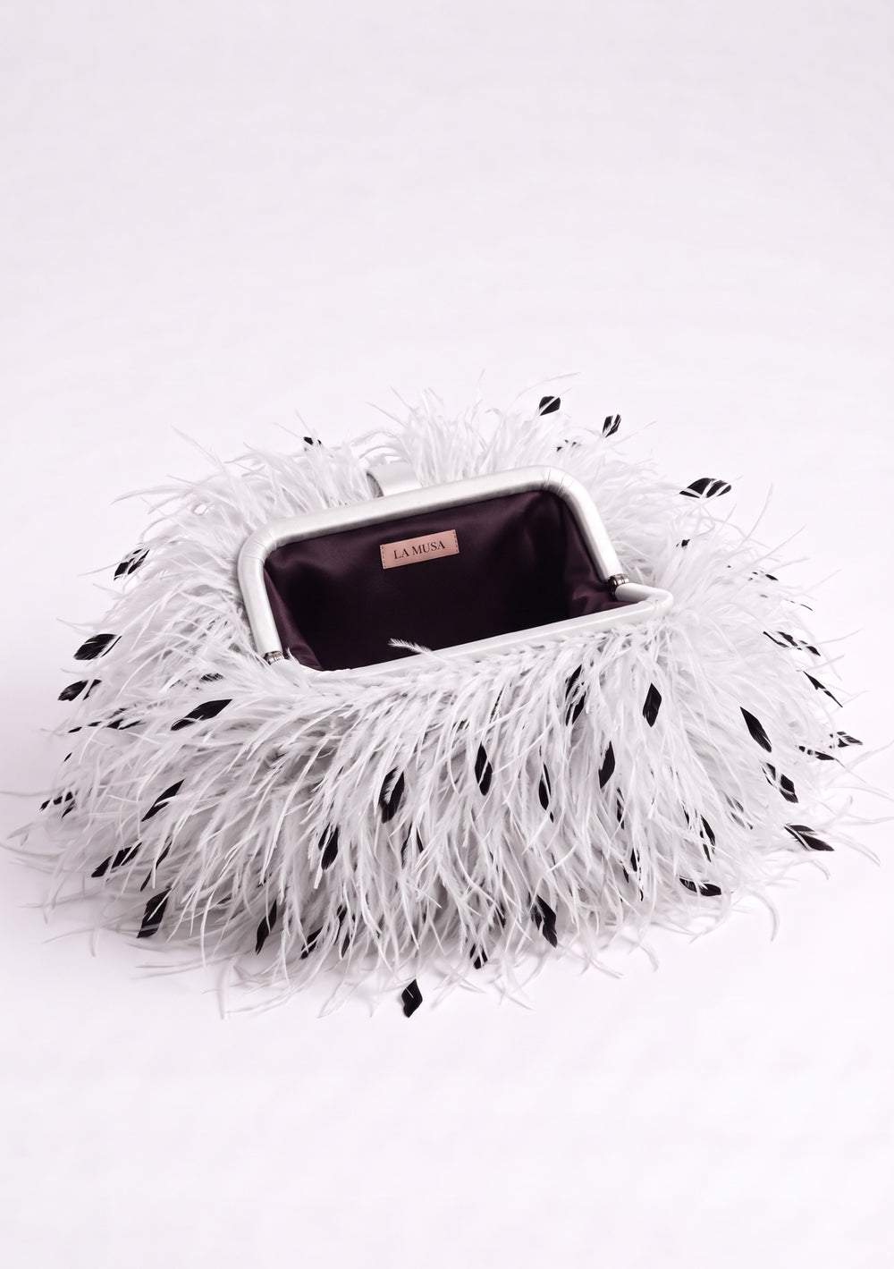 White Feather Bag open: white ostrich feather clutch with black flecks, silver-tone frame and plum lining.