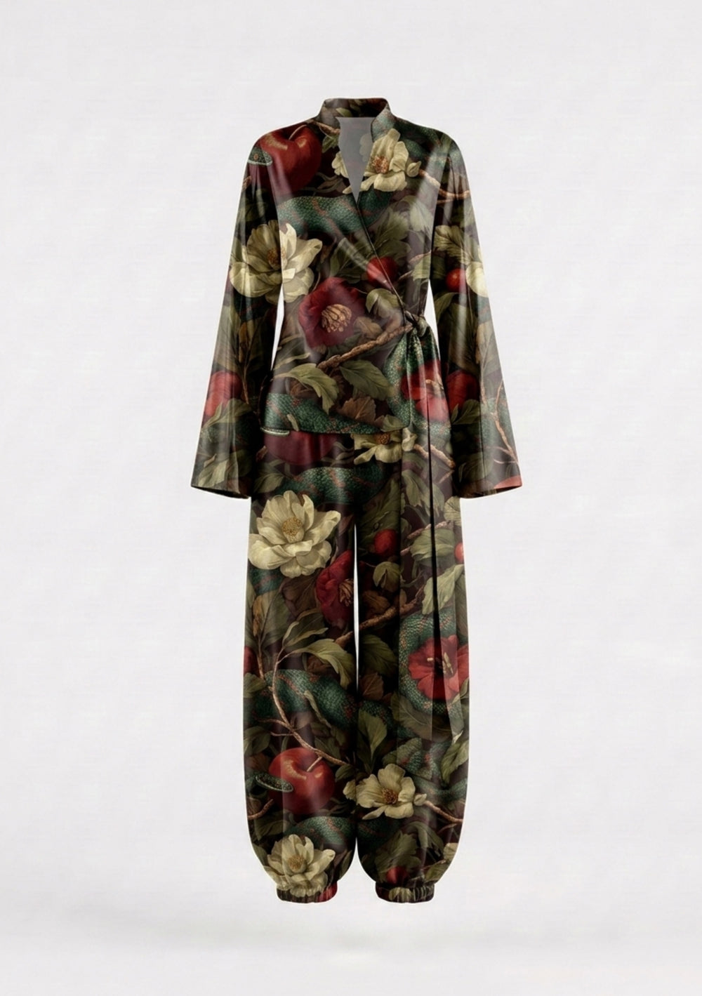 Eden silk set on model, wrap top with stand collar and wide flared cuffs tied at the waist over wide trousers gathered at the ankle, in a dark garden print of magnolias, apples and serpents