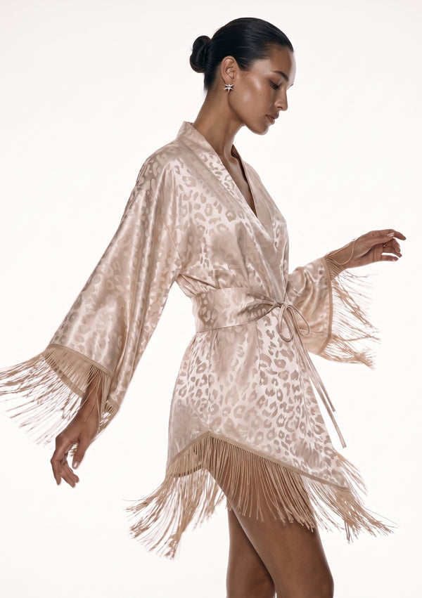 Feline robe in profile with the sleeve lifted, fringe fanning out from the cuff and the hem