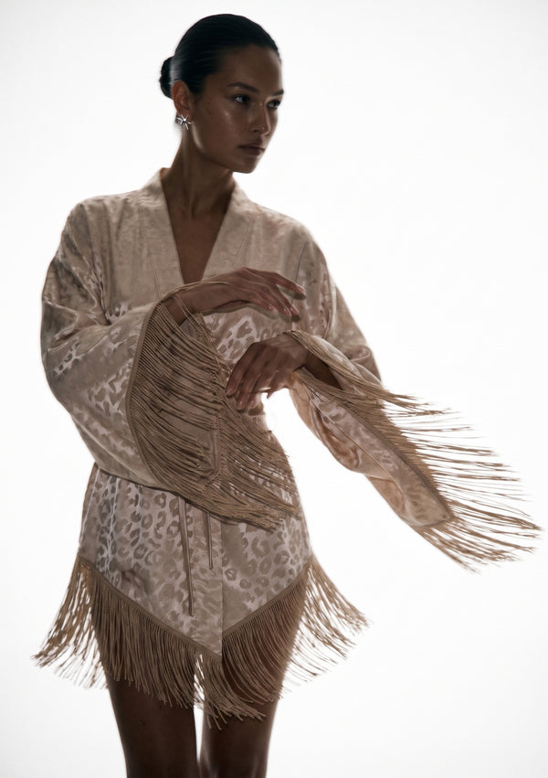 Feline robe caught mid-movement, fringe swinging out from the sleeve and the asymmetric hem