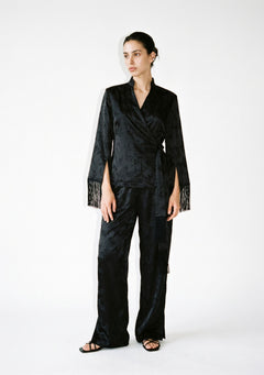Tenebrae Set on model, full-length front view of the black jacquard wrap top with fringed cuffs and side sash, matching wide-leg trousers