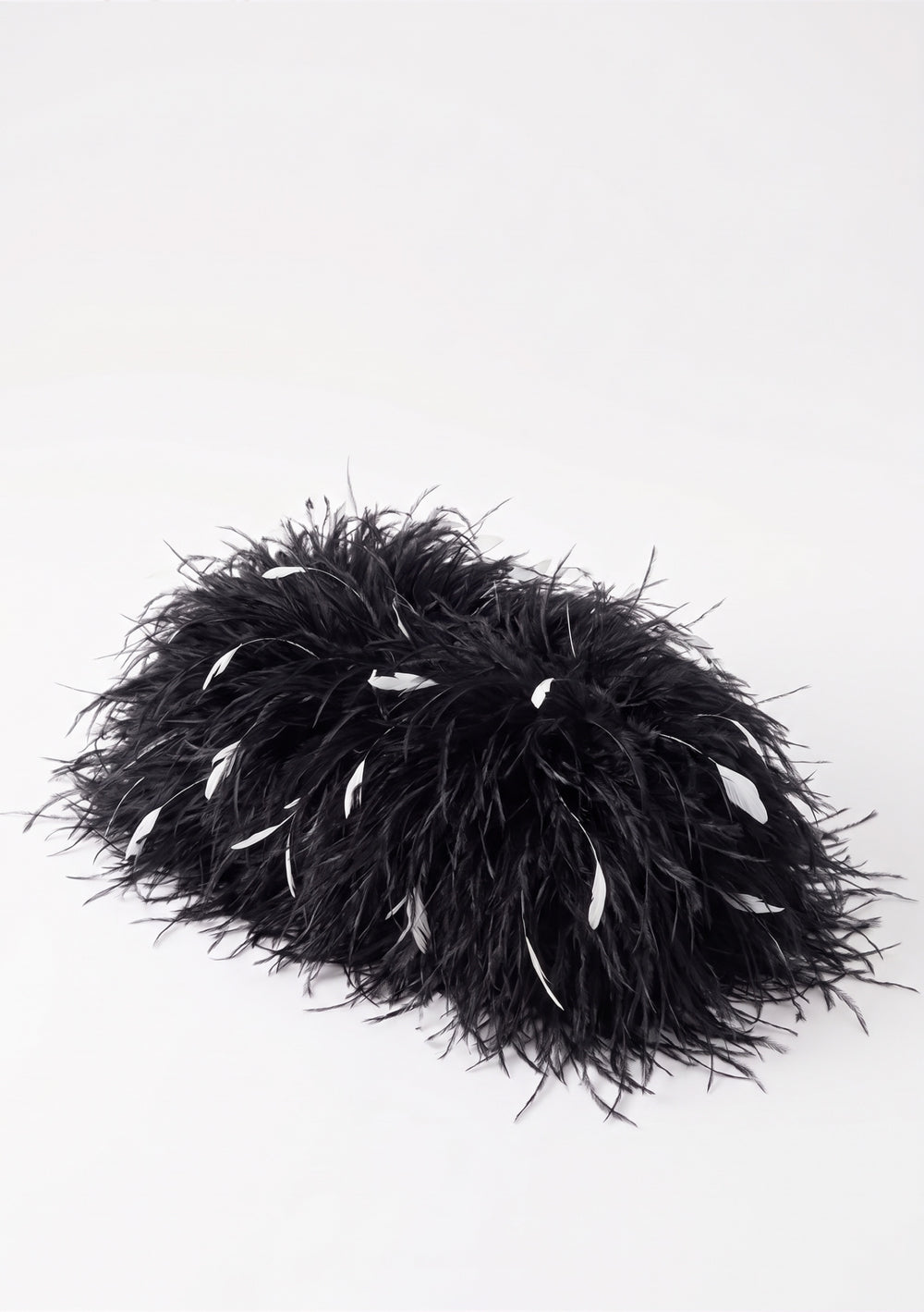 Black Feather Bag, an ostrich feather clutch in black with scattered white feathers, top view.