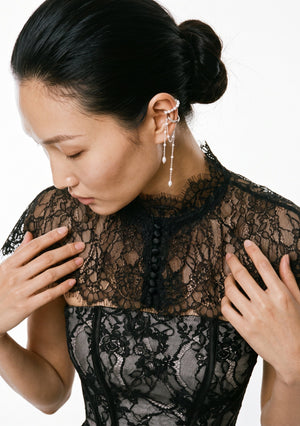 Close-up of Eclipse Cape mandarin collar and fabric-covered button closure over a black lace corset