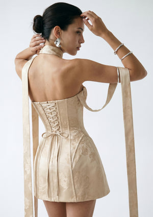 Nacre dress back view showing the corset lace-up and cascading champagne ribbons