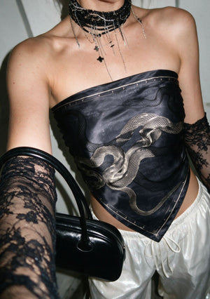 Model styling the Temptation silk scarf as an asymmetric bandeau top with lace gloves, a beaded choker and a black patent bag