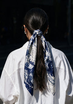 Mirage Peony Scarf knotted around a low ponytail with long printed ends falling over a white shirt