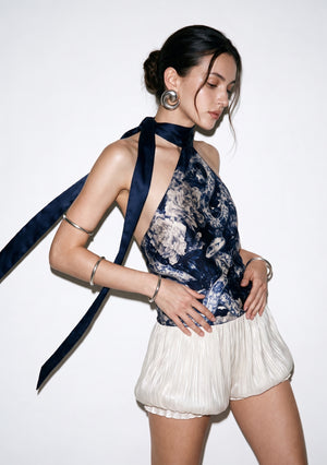 Mirage Peony silk halter top in movement, the navy ties swept to one side and the deep armhole of the open back visible