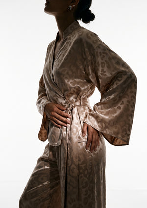 Close view of the Feline wrap shirt, stand collar splitting into a V and the sash knotted at the side waist