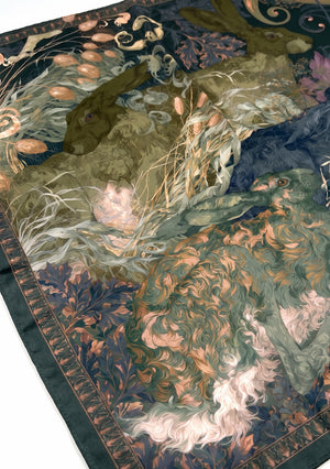Angled corner of the Eostra silk scarf, showing the hares in the grasses and the finished edge of the border