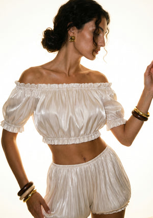Sirocco cream satin-chiffon bloomer shorts front three-quarter close-up worn on-model, showing the off-shoulder crop top neckline and bloomer waistband