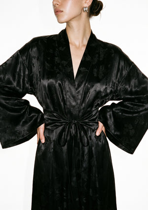 Detail of the Tenebrae robe, deep V shawl collar over the wide belt tied in a bow, with the wide bell sleeves falling either side