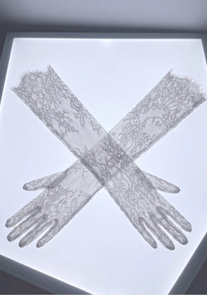 Pair of Etherea white floral lace opera gloves laid crossed on a lightbox, showing the full opera length and eyelash-fringe opening