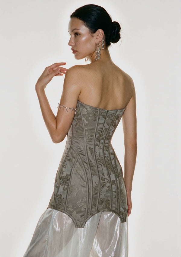 Back of the Lucentia jacquard corset mini dress with pointed hem over a sheer skirt, on model