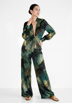 Green botanical print silk pajama set on model, front view, tie-front shirt with deep V neckline knotted at the waist and matching wide-leg trousers