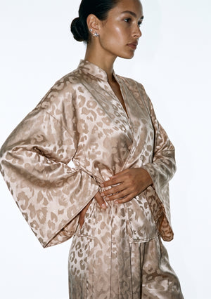 Three-quarter view of the Feline shirt, the wrap front and side tie seen against the tonal leopard weave