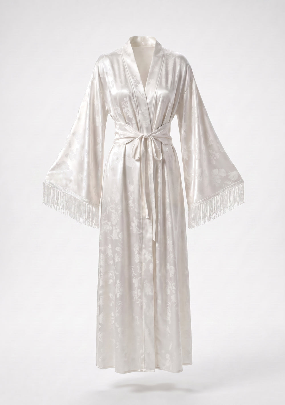 Moonveil ivory satin jacquard robe on model, floor-length wrap tied at the waist, long silk fringe falling from each wide sleeve