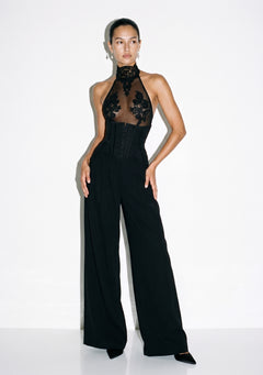 Black wide-leg corset trousers with front busk closure, worn with the sheer black Solo Lace Bodysuit, full-length front view.