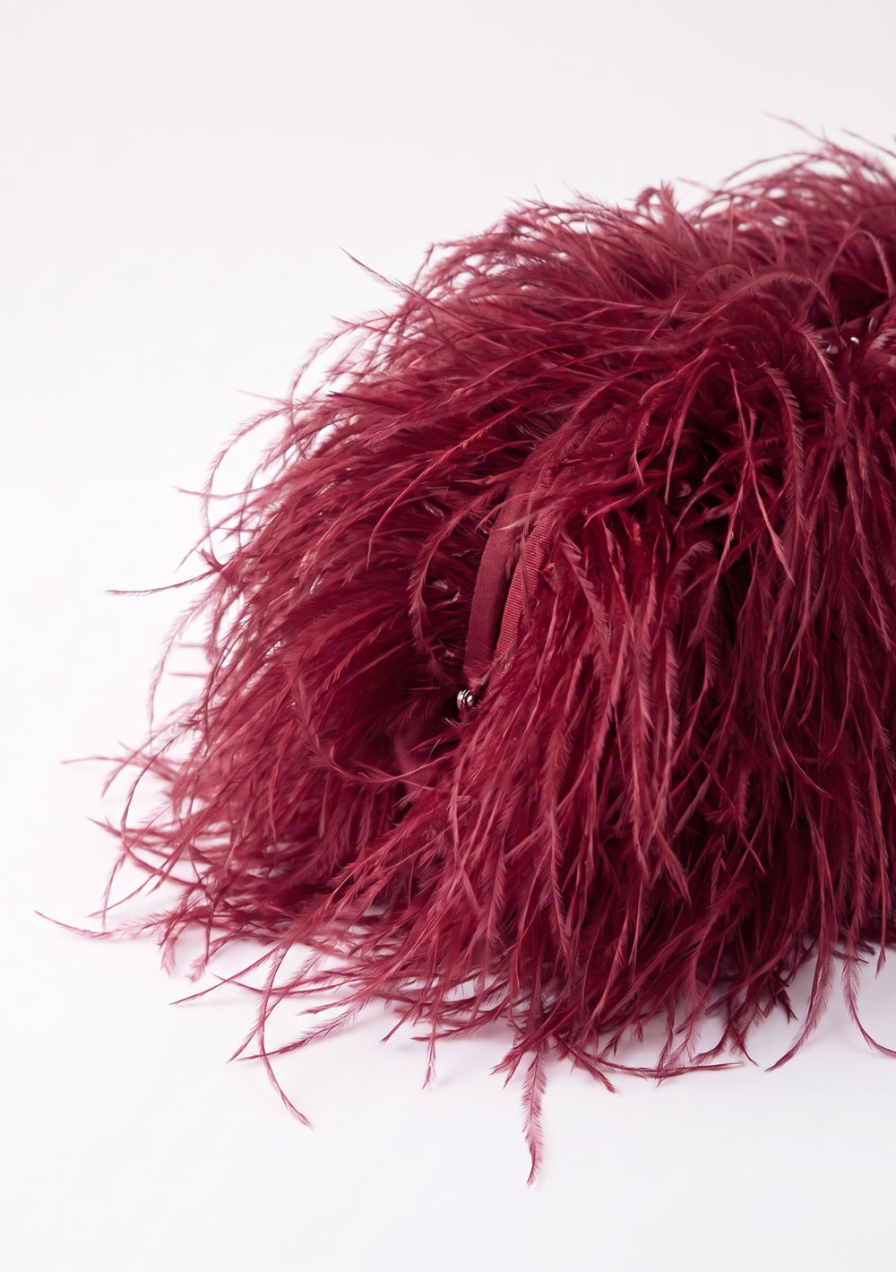 Burgundy Feather Bag, a wine-red ostrich feather clutch, side view.