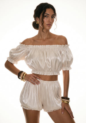 Sirocco cream satin-chiffon bloomer shorts front view worn on-model with hand on hip, showing the puff sleeve and bloomer silhouette