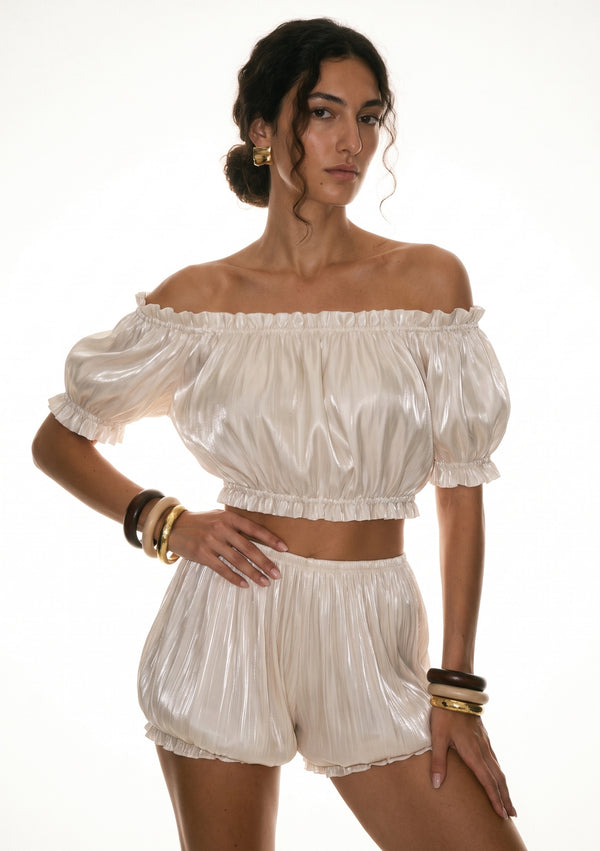 Sirocco cream satin-chiffon bloomer shorts front view worn on-model with hand on hip, showing the puff sleeve and bloomer silhouette