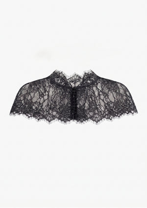 Eclipse Cape black lace capelet laid flat, showing scalloped eyelash fringe hem and covered-button front