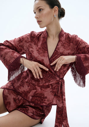 Crimson Dusk Mini Set, seated close-up showing the crossover wrap, contrast piping and jacquard-style landscape print on the satin