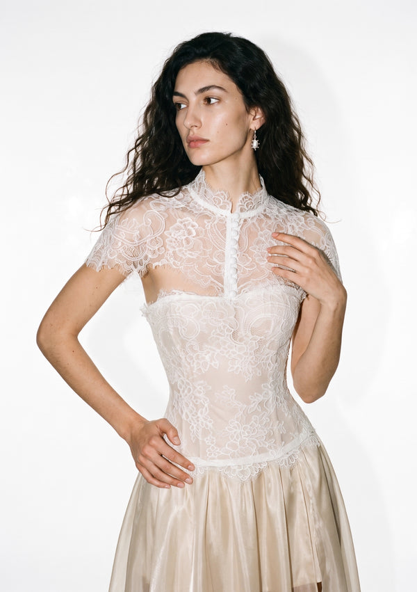 Etherea lace capelet worn over a corset, front view with scalloped shoulder edges