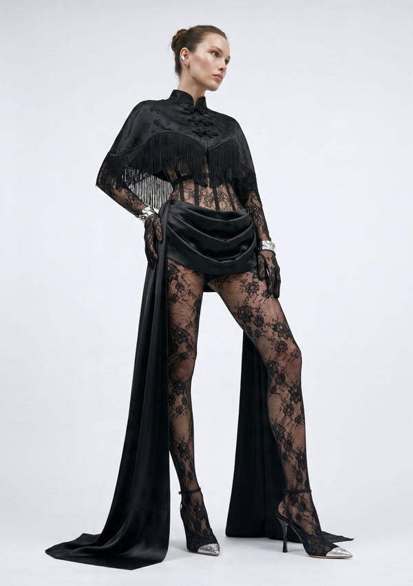 La Musa Baccara fringe capelet styled over the Baccara lace corset and draped satin skirt with lace tights, full-length view