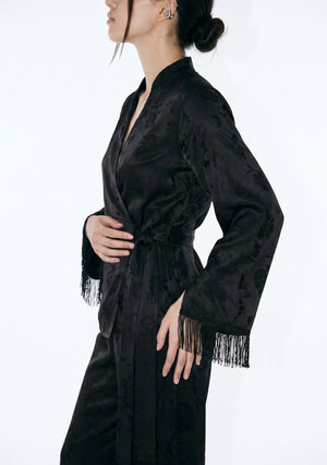 Side close-up of the Tenebrae Set, mandarin split neckline, side-tied satin sash at the waist and silk fringe trim on the sleeve cuff