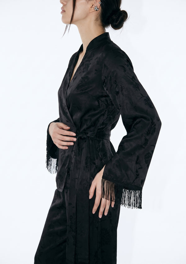Side close-up of the Tenebrae Set, mandarin split neckline, side-tied satin sash at the waist and silk fringe trim on the sleeve cuff