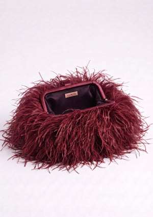Burgundy Feather Bag open: wine-red frame and dark plum lining with the La Musa label inside.