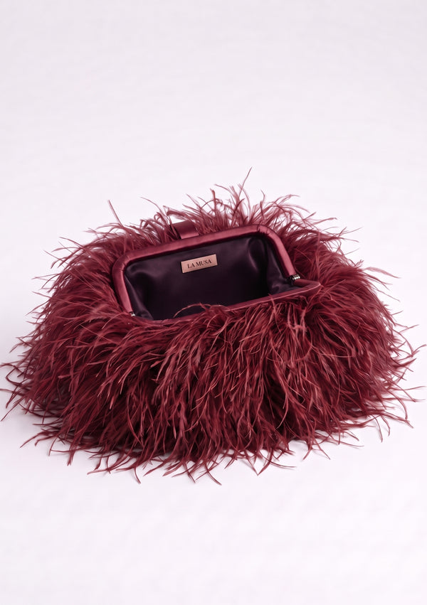 Burgundy Feather Bag open: wine-red frame and dark plum lining with the La Musa label inside.