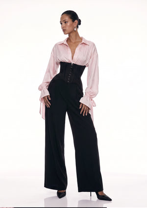 Full-length look: Petal Blouse in pink viscose with bow-tied cuffs, styled with the black wide-leg Elara Corset Trousers and heels.