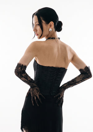 Back view of the Spell Corset showing the lace-up back, worn with the fringed Spell Skirt and lace opera gloves.