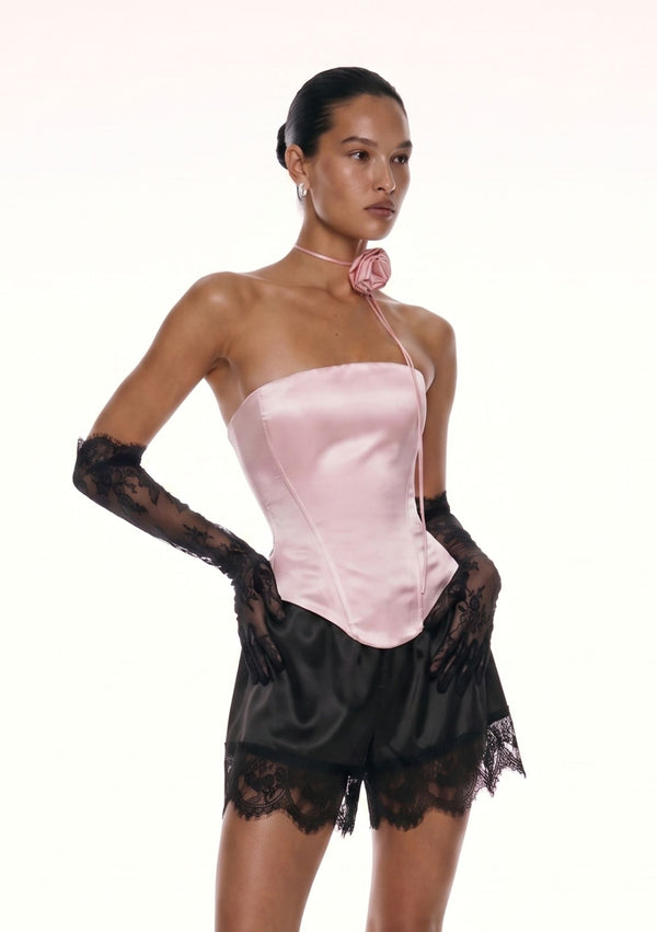 Pink satin Marshmellow corset three quarter view with rose choker, lace gloves and black lace shorts